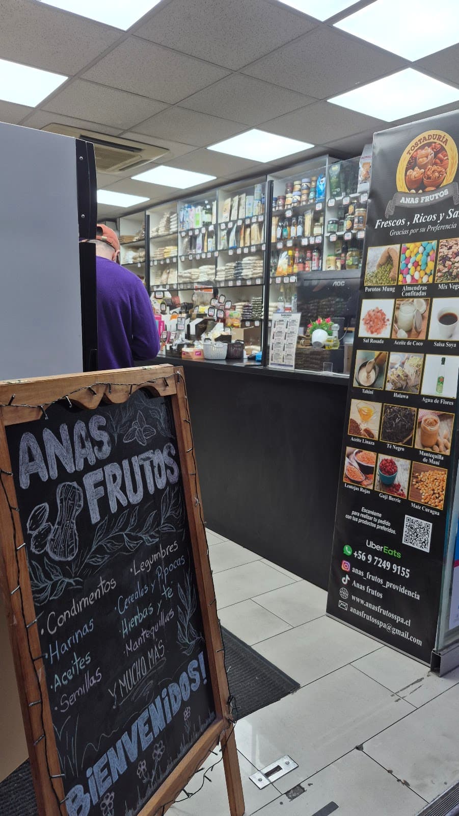 Interior del local de Anas Frutos en Providencia: mesón de atención y muro de frutos secos a granel